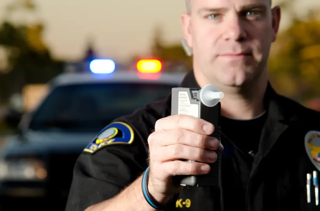 Picture of a police officer trying to work with someone who is going to refuse a breathalyzer test. 