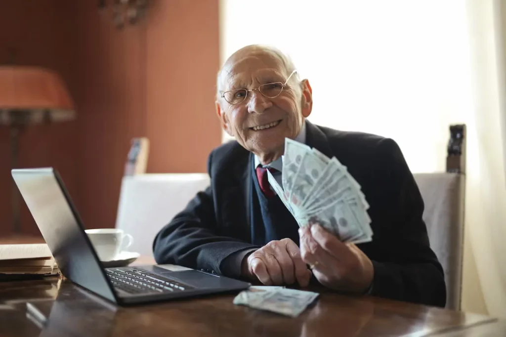 Picture of an elderly person holding money after receiving income benefits from learning about SSI vs SSDI.