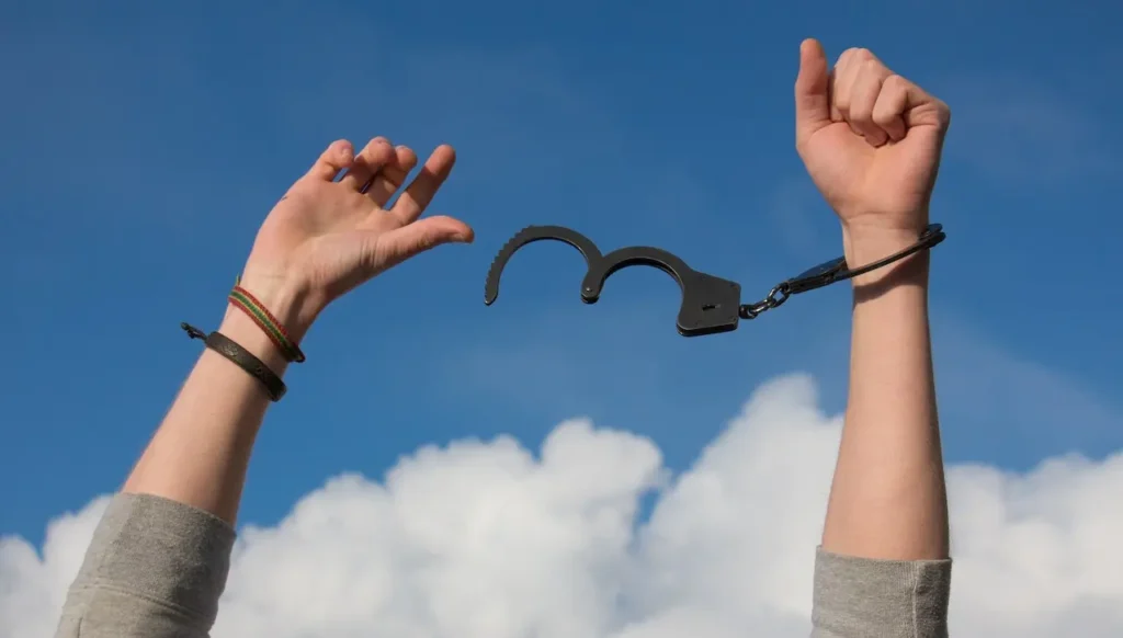 Picture of a person wearing handcuffs as they're breaking off for the article about getting a criminal record expunged.