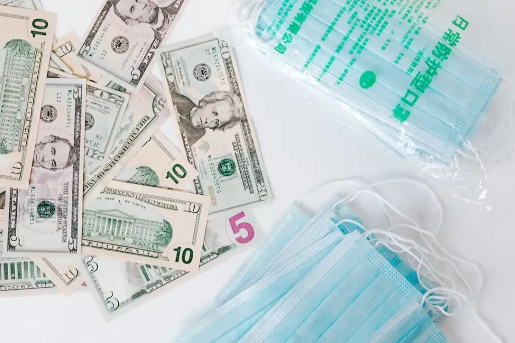 Picture of money and medical masks for the blog about filing a workers' comp claim.