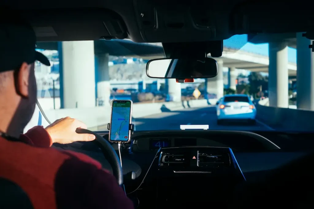 Picture of rideshare drivers in a car with GPS guiding the route.