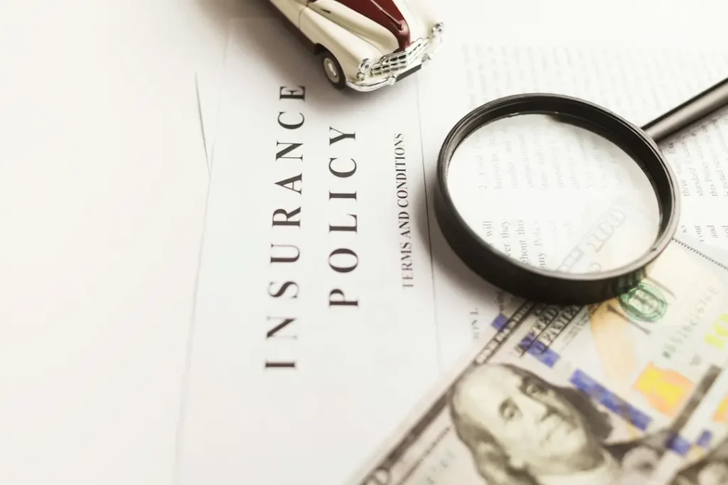 Picture of PIP insurance policy next to money and a toy car.