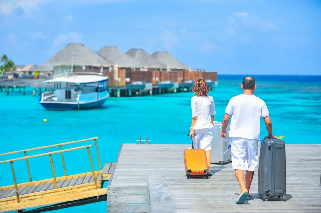 A couple walking toward a boat with suitcases - what to do if injured on vacation.
