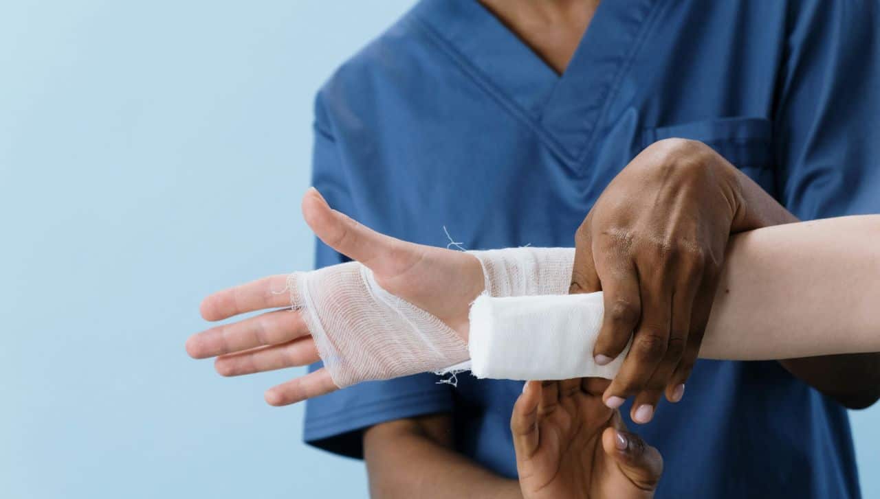 Picture of a doctor bandaging a broken hand 